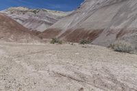 the large dirt field near a mountain is brown and sparse as it sits in the desert