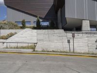 concrete steps and steps lead up to a building on the side of a mountain, under a cloudy blue sky