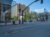 an empty street with buildings and parked cars on the sidewalks and green lanes on the sidewalk