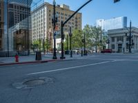 an empty street with buildings and parked cars on the sidewalks and green lanes on the sidewalk