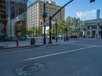 an empty street with buildings and parked cars on the sidewalks and green lanes on the sidewalk