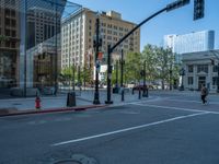 an empty street with buildings and parked cars on the sidewalks and green lanes on the sidewalk