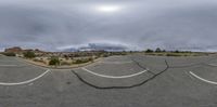 a panoramic image is of a view of a street with mountains in the background