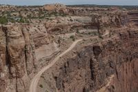 the view of the canyon from a distance, including a road, some of which is cut through the rock walls