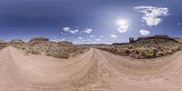 this is an image of the view from below of a dirt road with a big sky