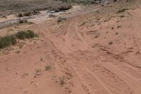 there is a motorcycle parked on the sand in the desert between two hills and large rock formations