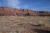 a dirt field with rocks in the background, and no people walking around, in the foreground