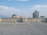 several large empty parking spaces in the city with buildings nearby in front of them -