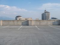 several large empty parking spaces in the city with buildings nearby in front of them -