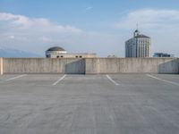 several large empty parking spaces in the city with buildings nearby in front of them -