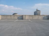 several large empty parking spaces in the city with buildings nearby in front of them -