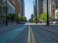 an empty street with buildings and parked cars on the sidewalks and green lanes on the sidewalk