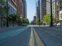 an empty street with buildings and parked cars on the sidewalks and green lanes on the sidewalk