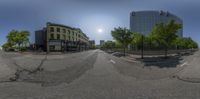 view of intersection, taken from a fish eye lens of trees in front of buildings