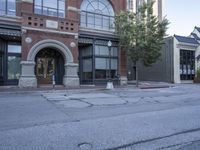 the view of a building, street with parking meters and trees in front of it