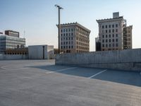 several large empty parking spaces in the city with buildings nearby in front of them -