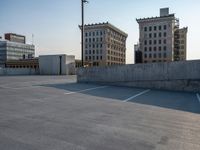 several large empty parking spaces in the city with buildings nearby in front of them -