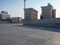 several large empty parking spaces in the city with buildings nearby in front of them -