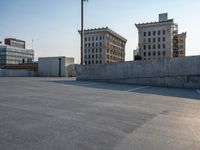 several large empty parking spaces in the city with buildings nearby in front of them -