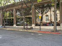 parked bicycles in front of an office building on a street corner in a city with tall windows