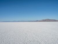 the view from an airplane of the vast expanse of salt flats and mountains in the distance