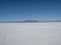 the view from an airplane of the vast expanse of salt flats and mountains in the distance