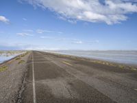 the road is empty with no people on it and is near the ocean in the background