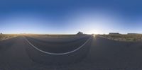 an empty open road surrounded by desert and mountains with a sky background, from which one is the center point of view