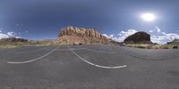 a curved street that has a mountain in the background and white lines going from each side