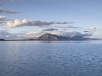 a large body of water with mountains on both sides of it and clouds in the sky