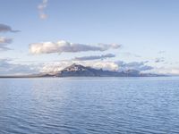 a large body of water with mountains on both sides of it and clouds in the sky