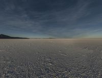 an empty desert is shown with blue skies and clouds above it in this image, there are two people and one is taking a picture