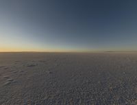 there are a bunch of footprints in the snow, with a sky background for a backdrop