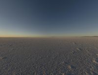 there are a bunch of footprints in the snow, with a sky background for a backdrop