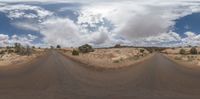 a view of a very empty dirt road, in front of a cloudy sky with some clouds