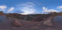 a picture from a 3d video of clouds over a valley of rock formations in the background