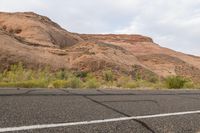 a motorcycle rider in an area of barren land, as if by a bus, makes his way across the desert