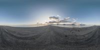 a view of a mountain, sea and mountains through the sun rays through a hole in the sand