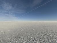 an empty desert with a clear sky and clouds in the background a few feet apart from a flying camera