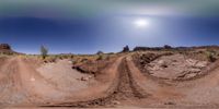 a dirt track running on top of a dirt hill in the desert during a sunny day