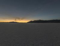 a sunset is seen over a vast desert plain with a person standing on one step