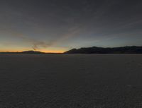 a sunset is seen over a vast desert plain with a person standing on one step