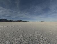 an open desert with no one yet on it and mountains behind it in the background