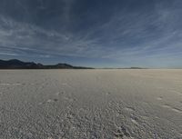 an open desert with no one yet on it and mountains behind it in the background