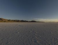 a vast desert with no people or clouds in it, including mountains and blue skies