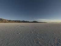 a vast desert with no people or clouds in it, including mountains and blue skies