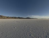 a vast desert with no people or clouds in it, including mountains and blue skies