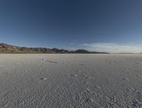 a vast desert with no people or clouds in it, including mountains and blue skies