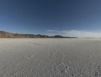 a vast desert with no people or clouds in it, including mountains and blue skies