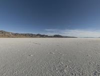 a vast desert with no people or clouds in it, including mountains and blue skies